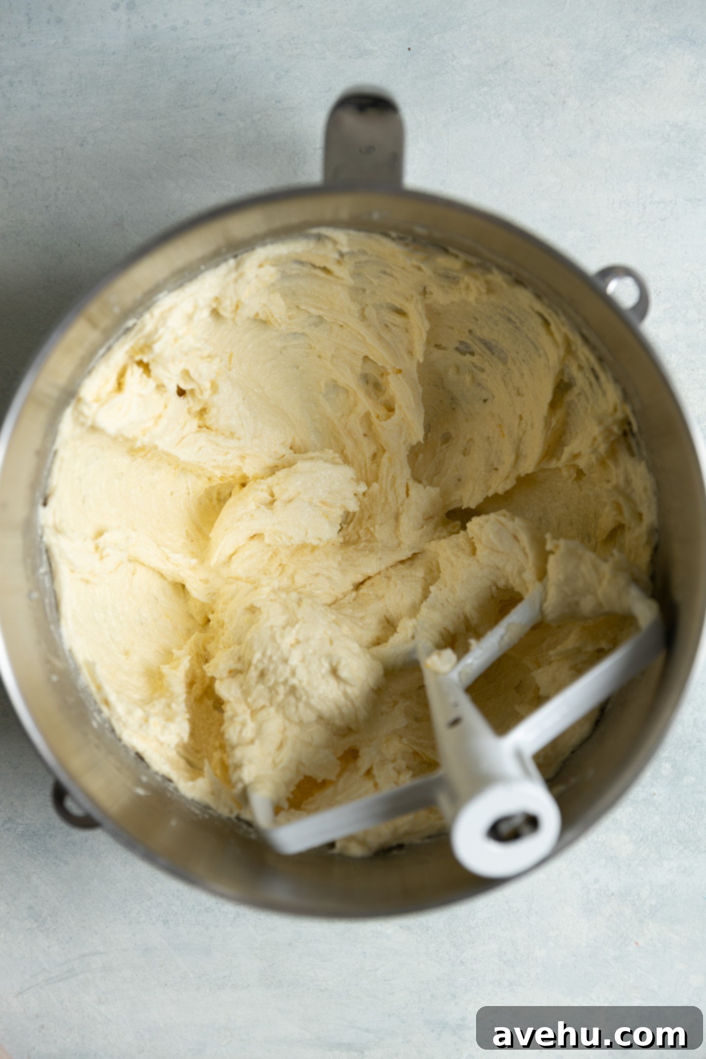 Bright & Zesty Lemon Blueberry Cupcakes 5 A creamy, pale yellow batter containing butter, sugar, lemon zest, oil, and eggs in a mixing bowl, perfectly blended and ready for dry ingredients.