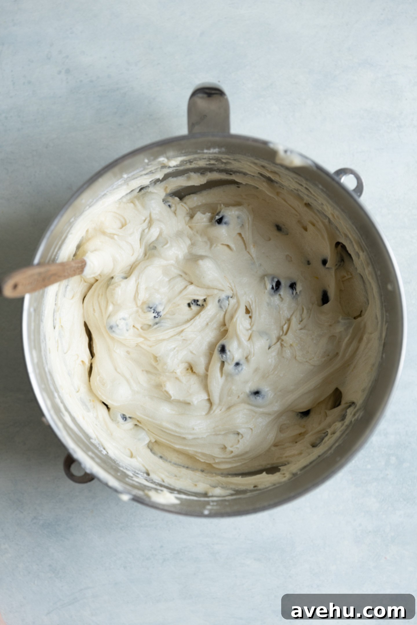 Bright & Zesty Lemon Blueberry Cupcakes 8 Cupcake batter with whole, vibrant blueberries gently folded in, sitting in a mixing bowl, highlighting the even distribution of fruit.