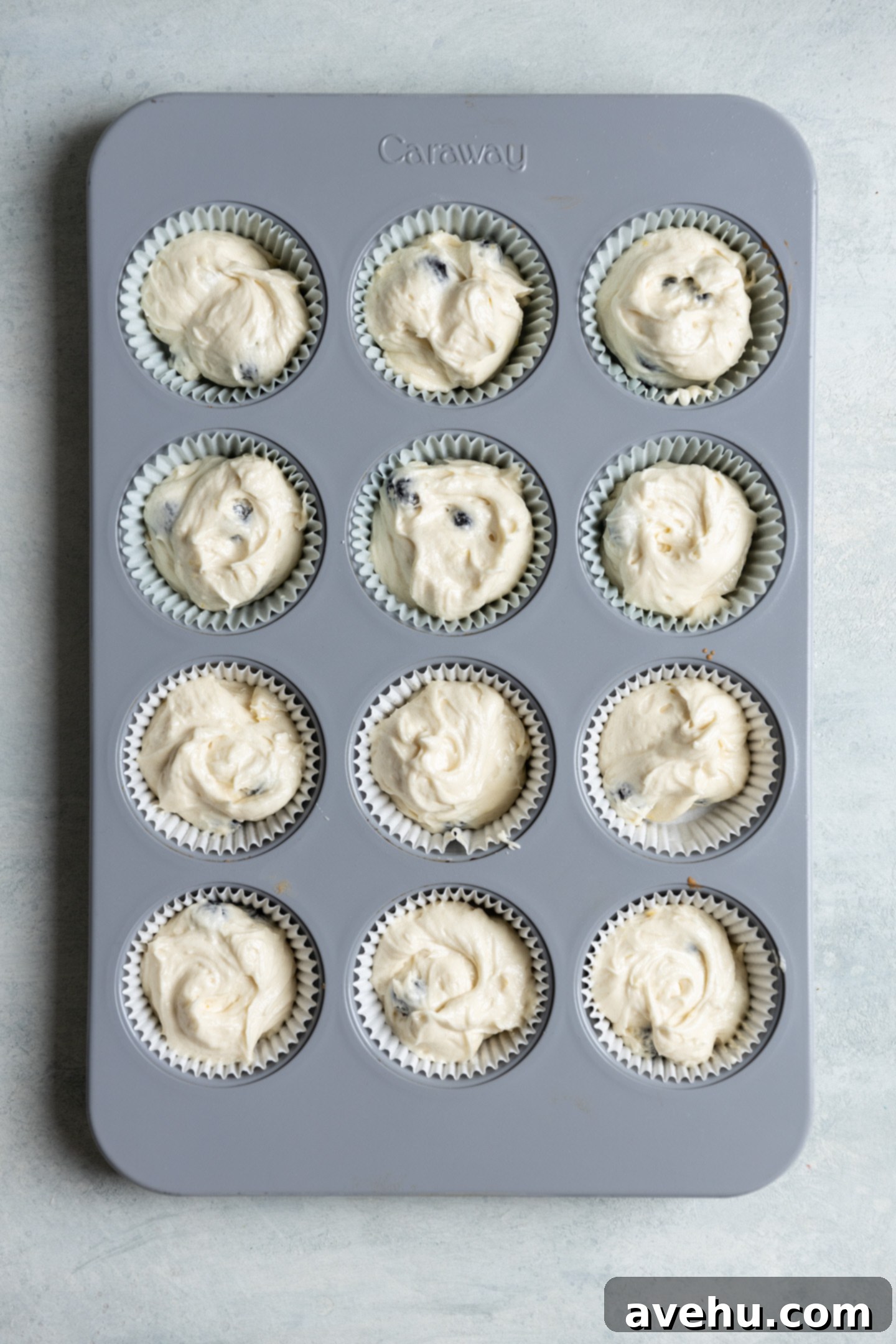 Bright & Zesty Lemon Blueberry Cupcakes 9 A muffin tin neatly filled with lemon blueberry cupcake batter, ready for baking, showcasing the perfect ¾ full measurement.