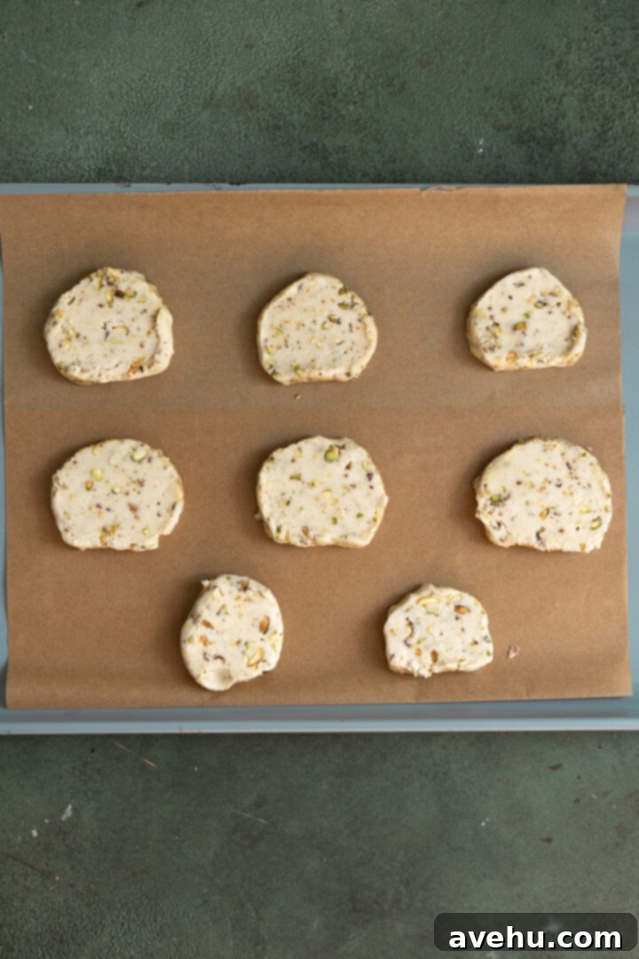 Buttery Pistachio Shortbread Logs 11 A baking sheet filled with evenly spaced pistachio shortbread cookies, ready to be baked to golden perfection.