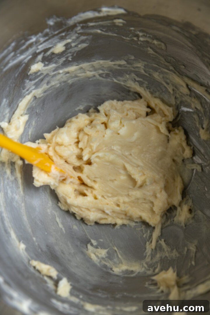 Buttery Pistachio Shortbread Logs 5 A close-up shot of butter and powdered sugar perfectly creamed together in a stand mixer bowl, showing a light and fluffy texture.