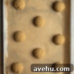 Easy 20 Minute Chip Free Chocolate Cookies 5 Cookie dough balls on a baking sheet lined with parchment paper.