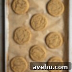 Easy 20 Minute Chip Free Chocolate Cookies 6 Baked chocolate chipless cookies on a parchment lined baking sheet.