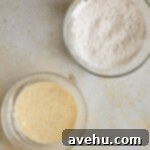 25 Minute Dreamy Mini Banana Bites 3 A bowl with wet ingredients and a bowl with dry ingredients on a beige backdrop.