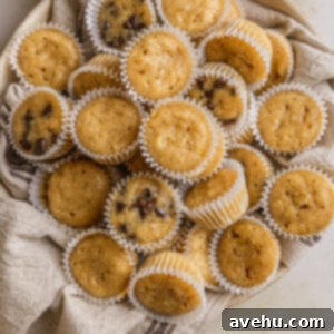 25 Minute Dreamy Mini Banana Bites 2 Mini banana muffins in a bowl lined with a linen napkin.