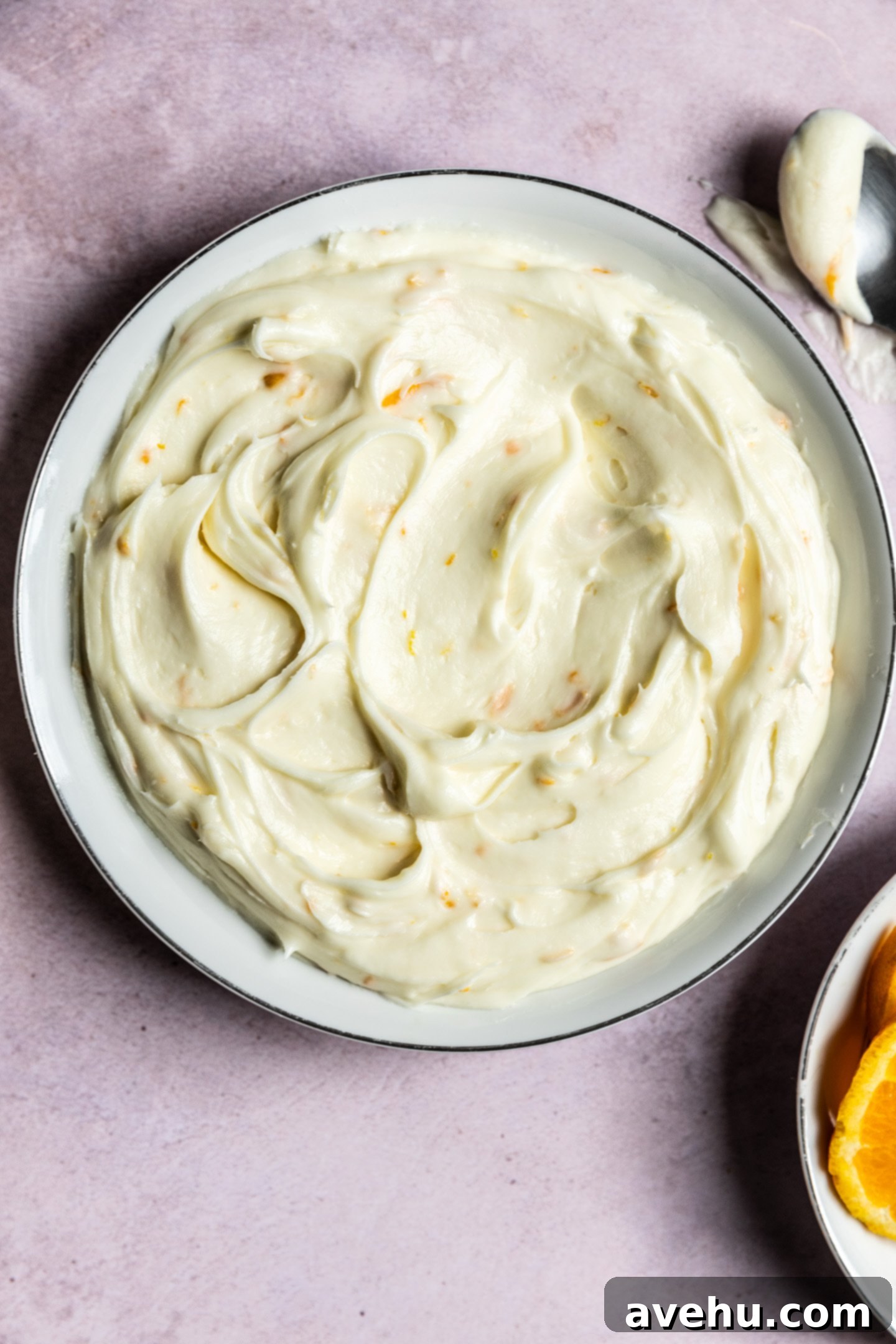 Orange Zest Cream Cheese Cloud 3 Orange cream cheese frosting swirled in a bowl.