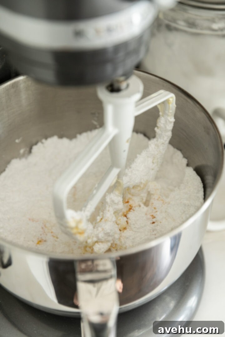 Orange Zest Cream Cheese Cloud 7 Powdered sugar added to a mixing bowl.