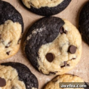 A perfectly baked one-batter brookies cookie, half rich brownie, half classic chocolate chip, presented on a minimalist beige background, highlighting its unique swirl.