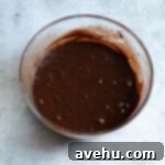 Effortless Chewy Brookie Bliss 3 Dark, smooth brownie batter in a glass bowl, ready to be spread.