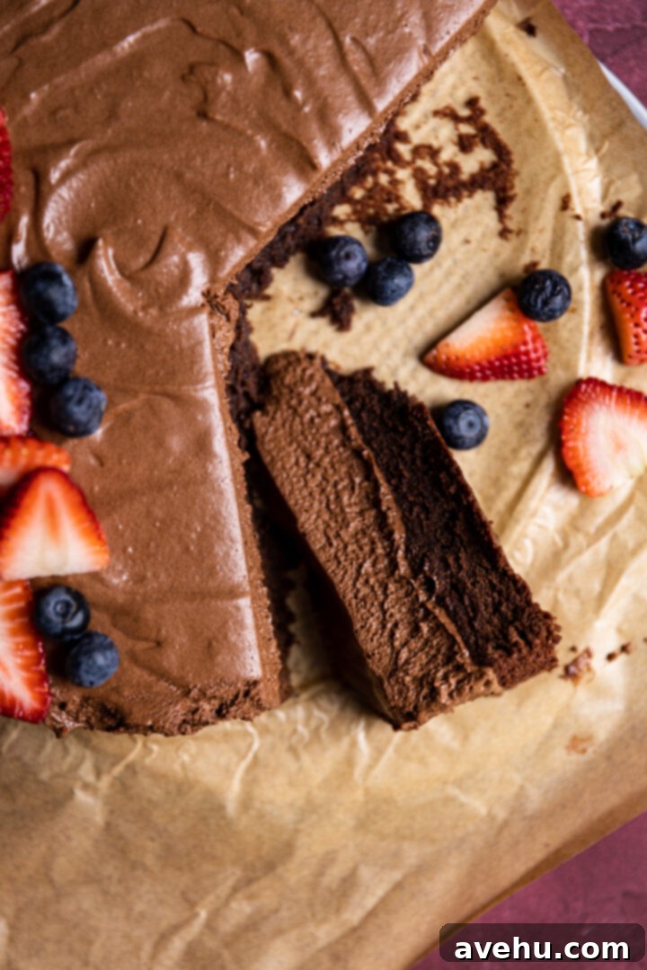 Velvet Chocolate Mousse Cake No Gelatin Needed 13 A slice of chocolate mousse cake on brown parchment paper.