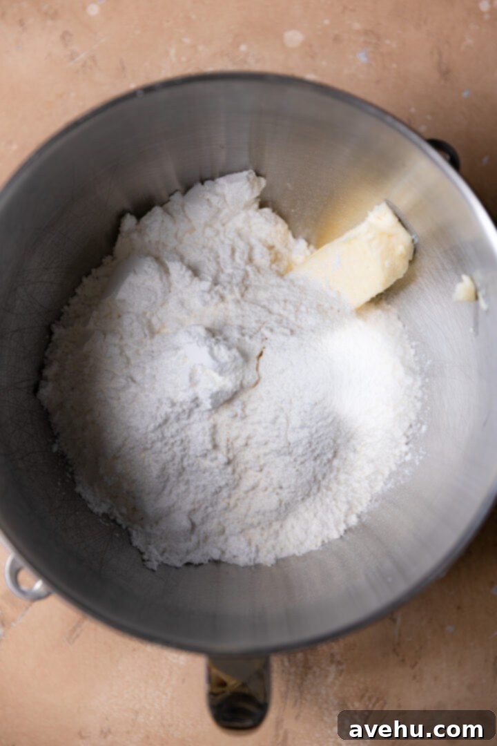 Silky Smooth Cookie Dough Frosting 6 Softened unsalted butter, powdered sugar, and heat-treated flour in a stainless steel mixing bowl, ready to be whipped into frosting.