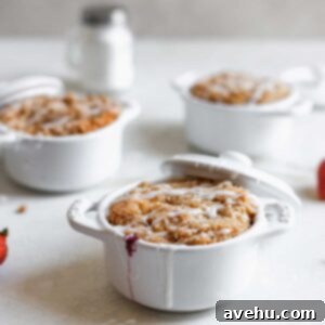Irresistible Mini Triple Berry Coffee Cakes 2 Triple berry coffee cakes baked inside mini staub cocottes on a white surface.