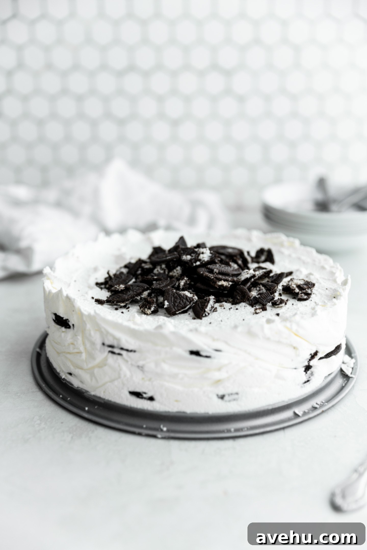 No-Bake 4-Ingredient Chocolate Dream 2 An icebox cake with crushed Oreos on top on a white surface.