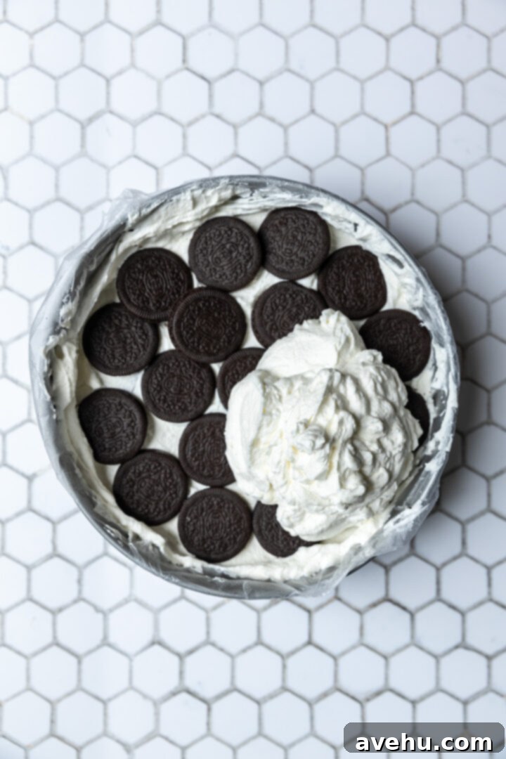 No-Bake 4-Ingredient Chocolate Dream 8 A huge dollop of whipped cream on top of a cookie layer in a sprong form pan.