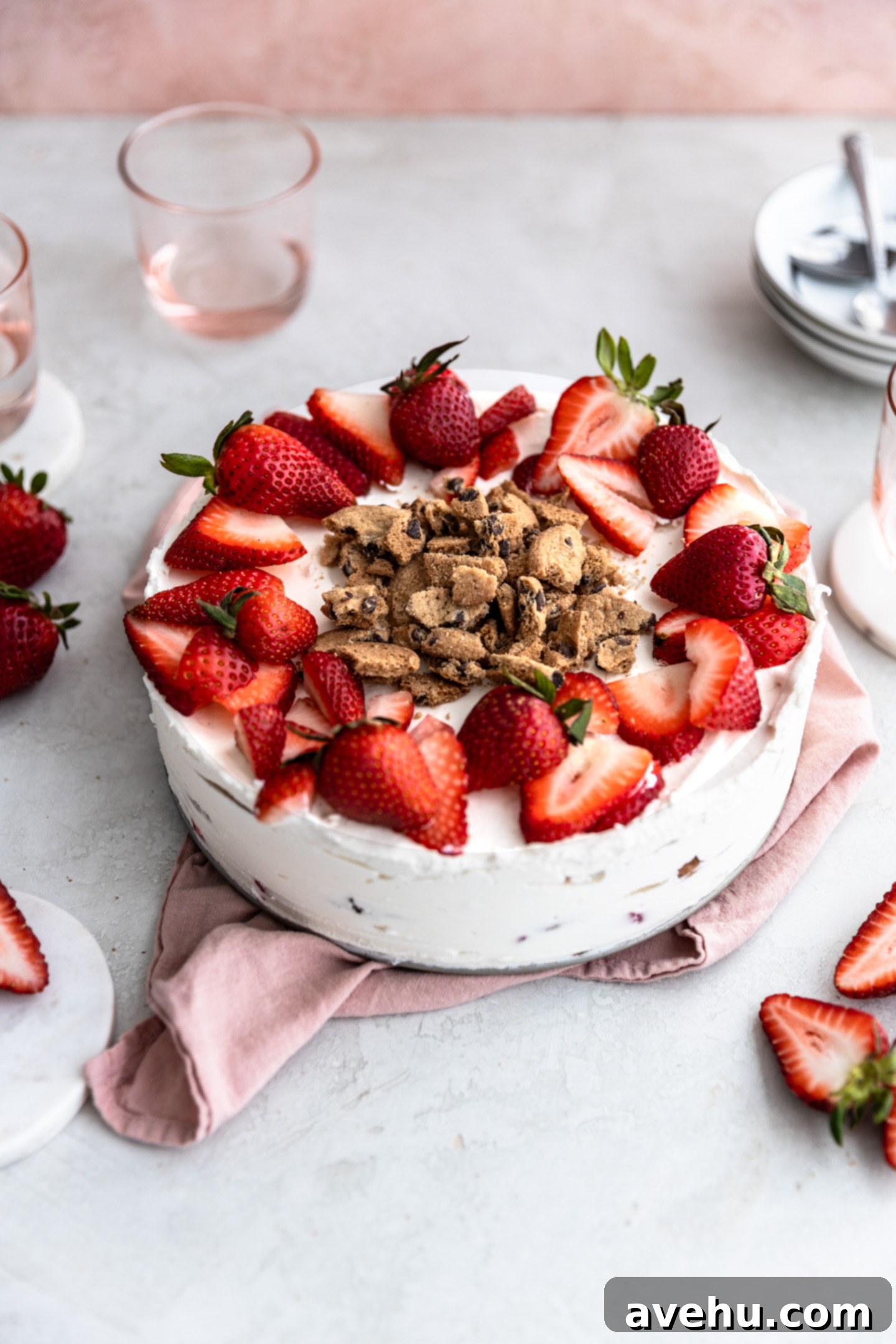 Chilled Strawberry Cloud Cake 2 A beautifully layered strawberry icebox cake, garnished with fresh strawberries and crushed chocolate chip cookies, ready to be served.