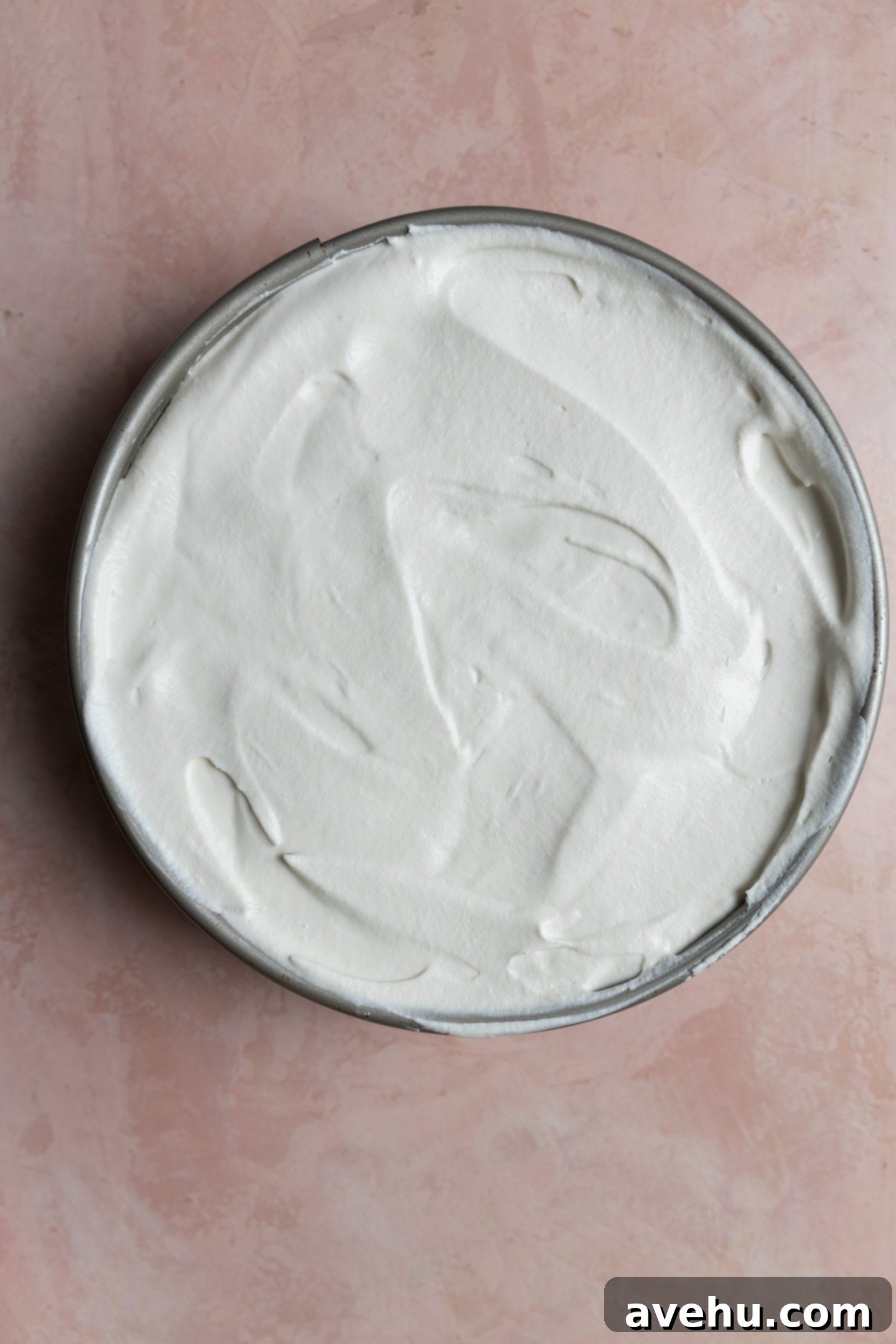 Chilled Strawberry Cloud Cake 10 A springform pan filled to the brim with a complete strawberry icebox cake, topped with a smooth layer of whipped cream, ready for the freezer.