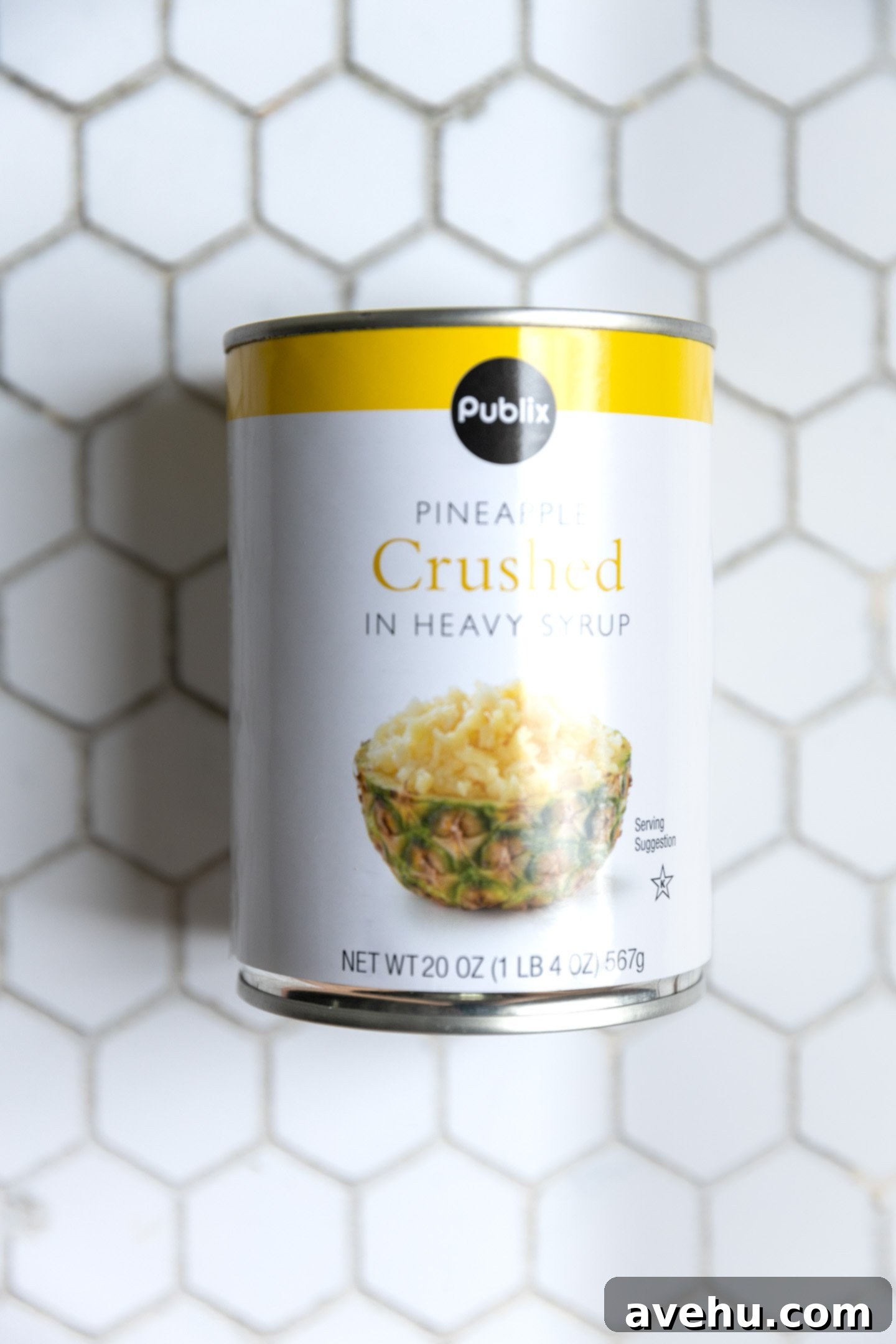 A crushed pineapple can on a tile surface, ready to be used in the cake.
