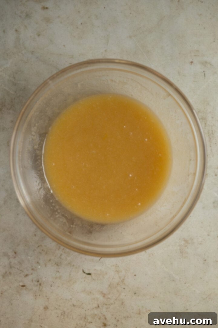 20-Minute Mixer-Free Sugar Cookies 4 Wet ingredients for sugar cookies in a bowl, showing a well-combined, light yellow mixture.