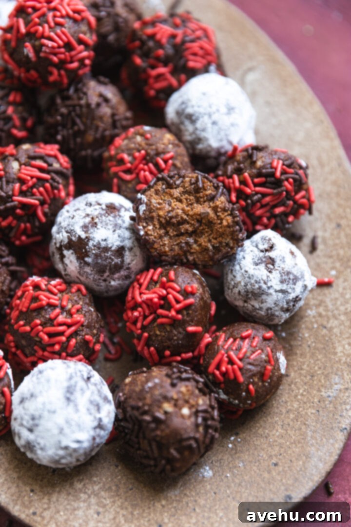 20-Minute Boozy Festive Rum Ball Recipe 11 A delicious rum ball with a bite taken out, revealing its moist, chewy interior, presented on a festive platter.