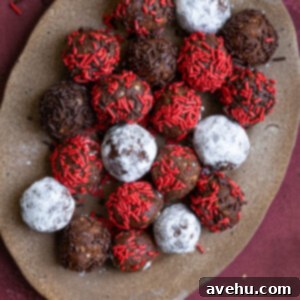 20-Minute Boozy Festive Rum Ball Recipe 12 Rum balls with different toppings on a brown platter.