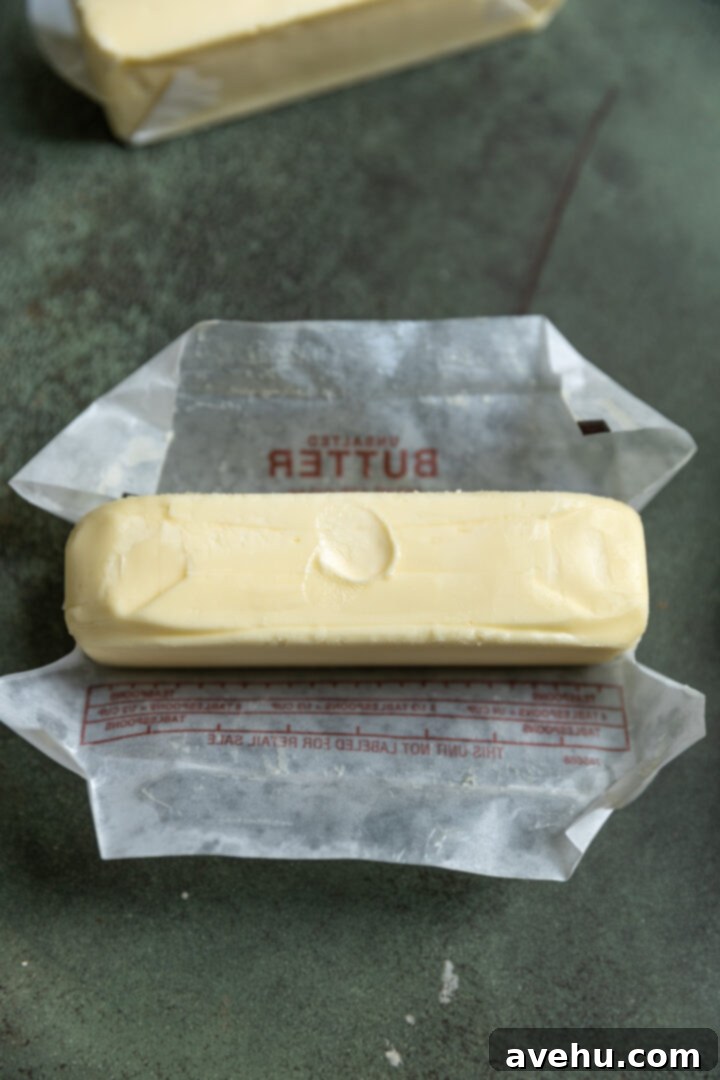 Effortless 3-Ingredient Snowball Cookies 3 Softened butter with a finger indent on it.