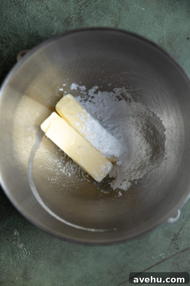 Effortless 3-Ingredient Snowball Cookies 4 Butter and powdered sugar in a stainless steel bowl.
