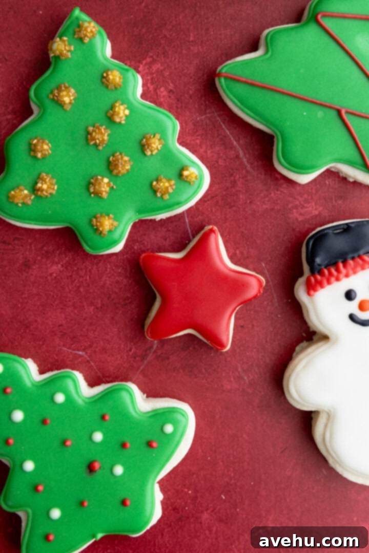 Instant Cut-Out Sugar Cookies 12 A star-shaped cut-out sugar cookie beautifully decorated, placed among other holiday cookies on a red surface.