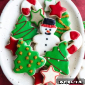 A plate of iced sugar cut out cookies decorated for Christmas.