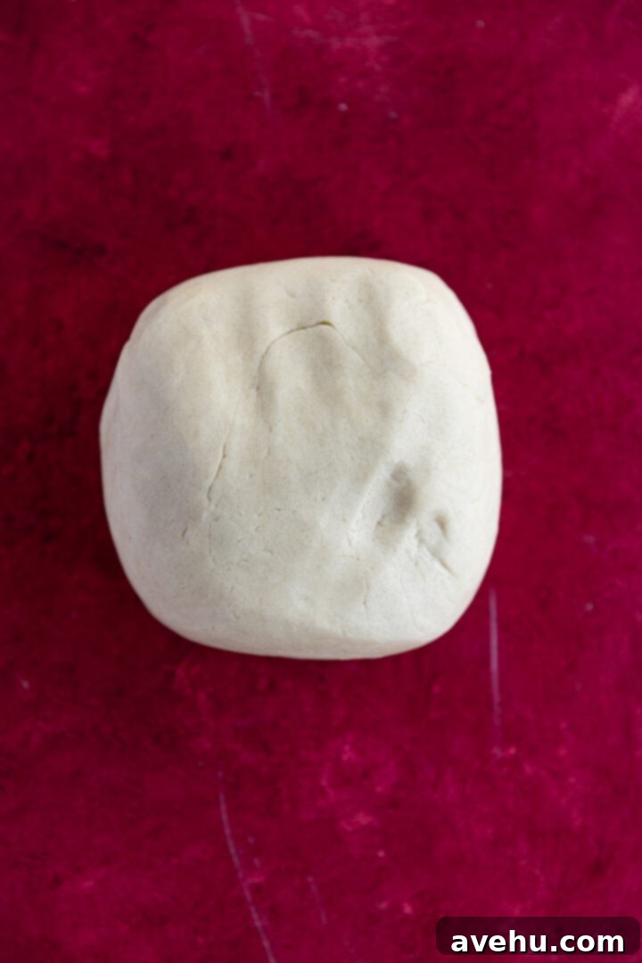 Instant Cut-Out Sugar Cookies 7 A perfectly smooth ball of sugar cookie dough on a vibrant red surface, ready for rolling.