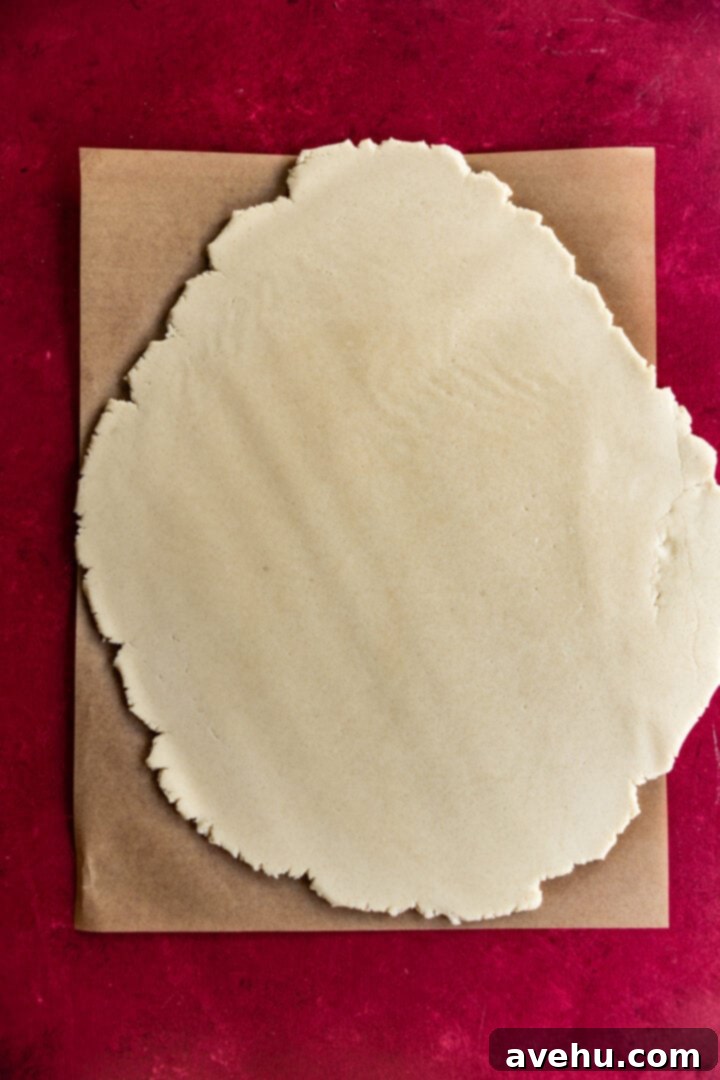 Instant Cut-Out Sugar Cookies 8 Sugar cookie dough rolled out evenly on a piece of parchment paper, ready for cutting.