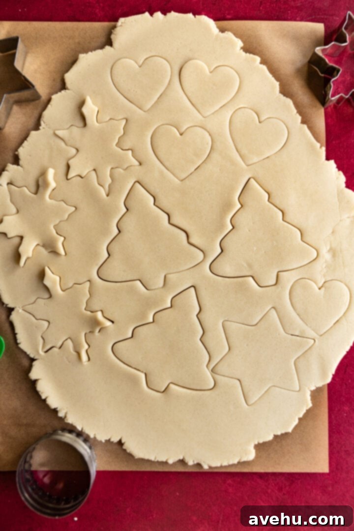 Instant Cut-Out Sugar Cookies 9 Various holiday shapes cut into sugar cookie dough on a baking sheet.