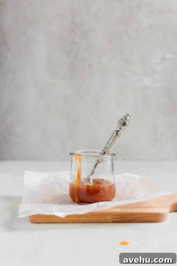 Decadent Dairy-Free Apple Cider Caramel Layer Cake 2 Dairy free caramel sauce styled in a jar with a pretty spoon sticking out.