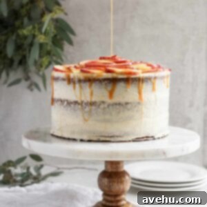 Decadent Dairy-Free Apple Cider Caramel Layer Cake 3 An apple cider cake styled on a light background with dairy free caramel drizzling on top.