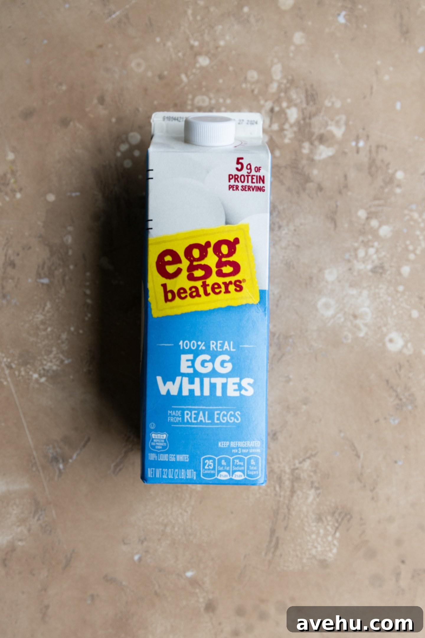 Quick Royal Icing Without Meringue Powder 3 Egg whites in a carton on a peachy background.