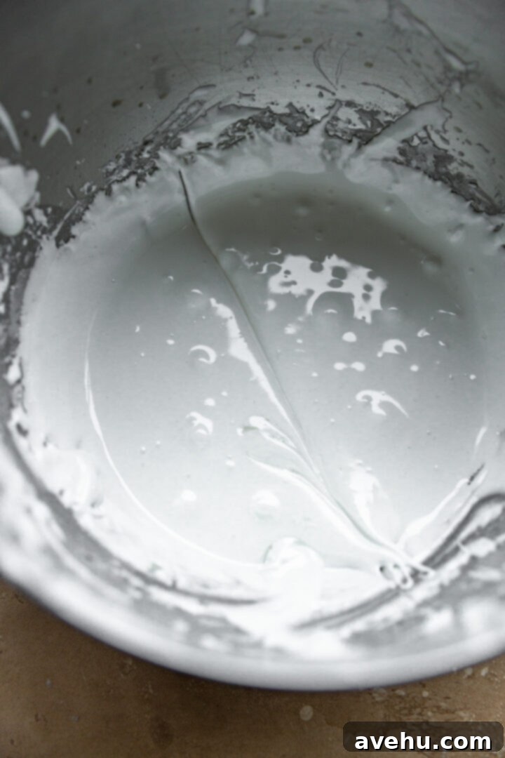 Quick Royal Icing Without Meringue Powder 7 Royal icing in a bowl with a line drawn through it.