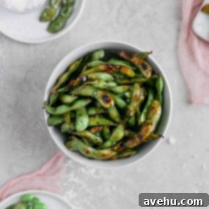 Quick and Crispy Blistered Edamame 2 Blistered edamame with soy sauce and lime in a bowl styled with pink cheesecloth on a gray background, a perfect quick and healthy side dish.