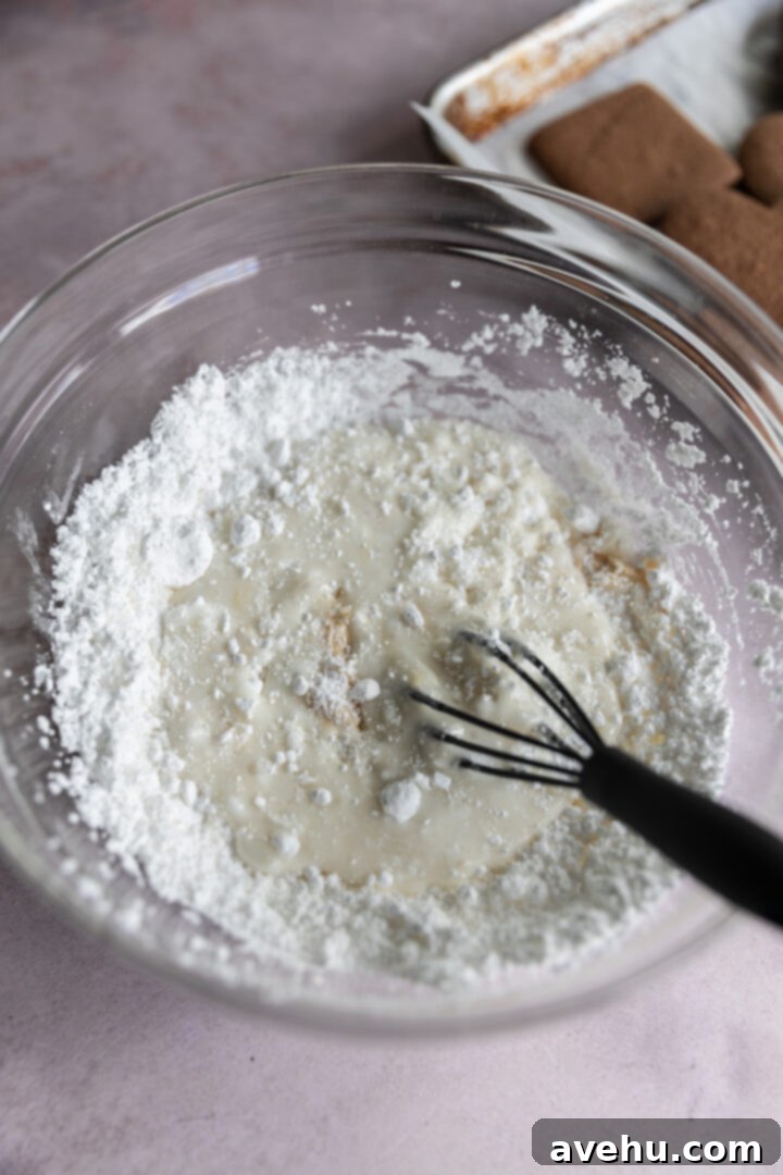 Quick No-Piping Cookie Icing 4 A whisk in a bowl mixing powdered sugar and liquids.