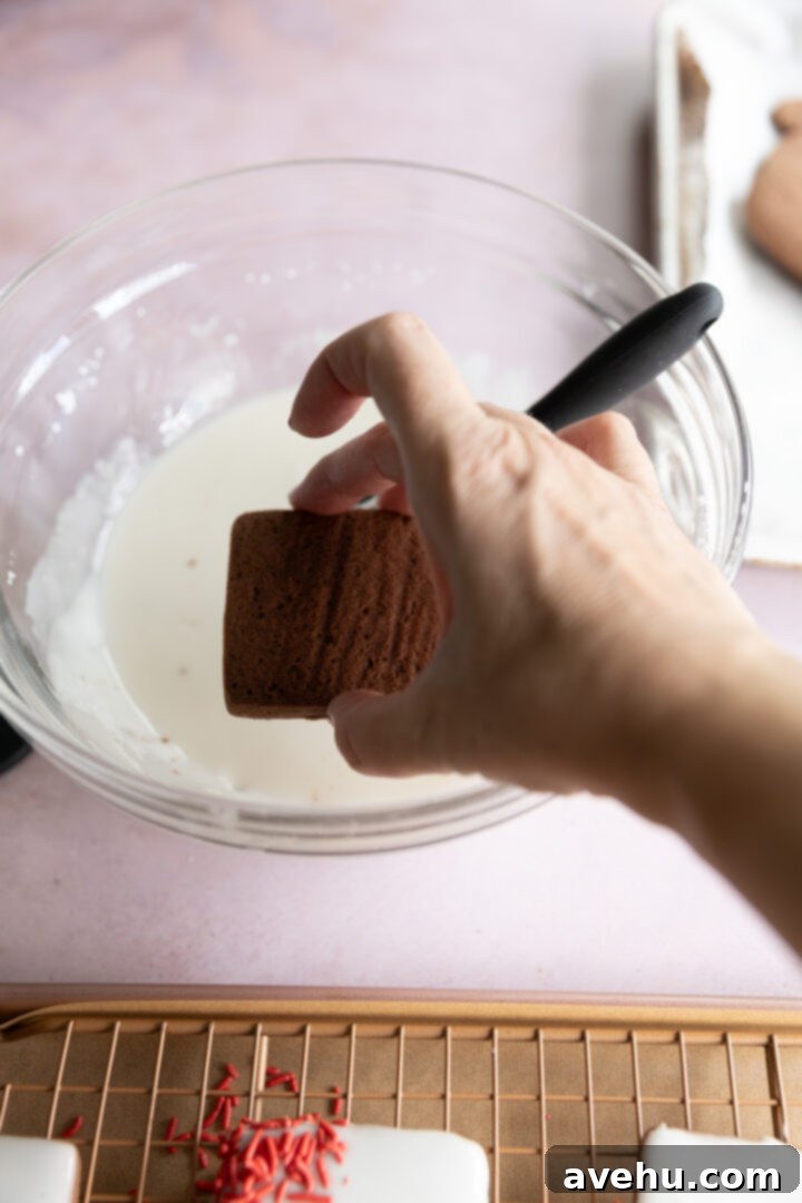 Quick No-Piping Cookie Icing 7 A cookie being dipped face first into a bowl of icing.