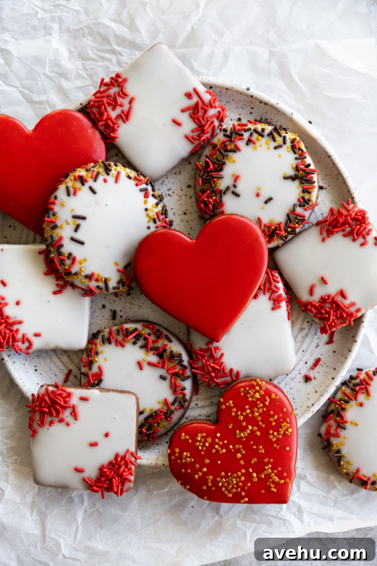 Instant Chocolate Sugar Cookie Delight 2 Beautifully decorated red and white cut-out chocolate sugar cookies with vibrant sprinkles on a speckled white plate, showcasing perfect heart shapes and crisp edges.