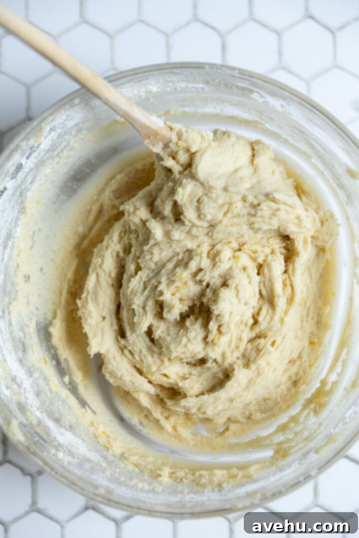 Zesty No-Chill Lemon Sugar Cookies 6 Lemon sugar cookie dough in a bowl with a wooden spoon.