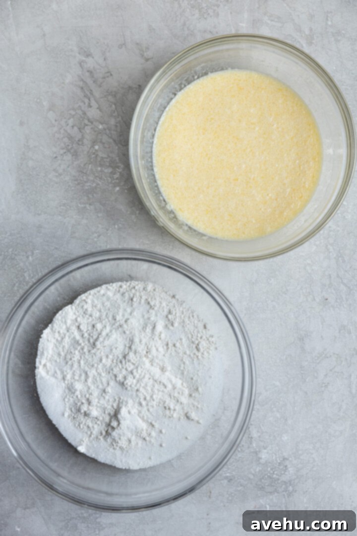Classic Soft & Moist Muffins 4 2 mixing bowls on a gray surface, one with dry ingredients and one with wet ingredients.
