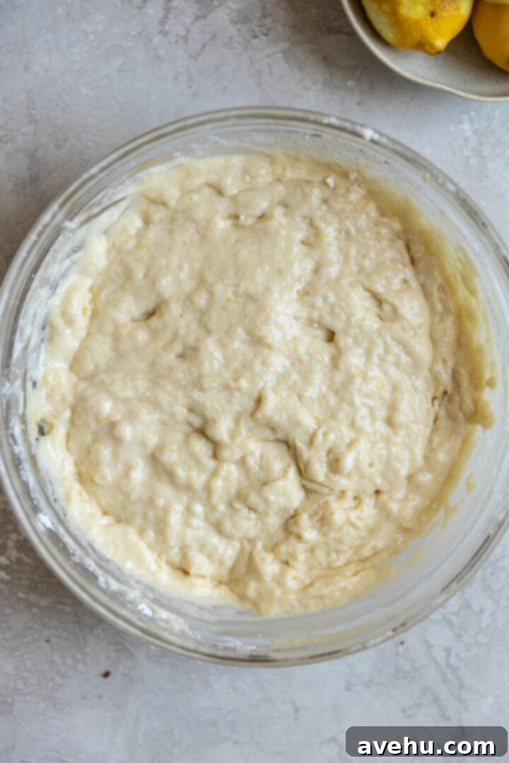 Gourmet Triple Lemon Muffins 8 Lumpy muffin batter in a mixing bowl, showing the ideal consistency before baking for tender muffins.