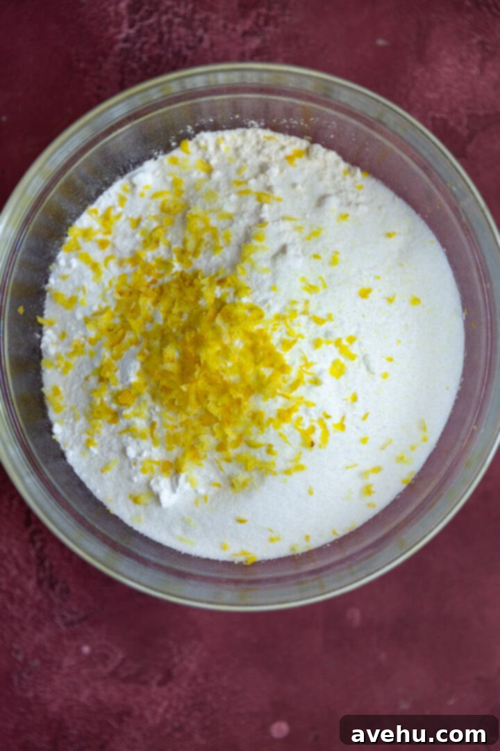 Luminous Lemon Raspberry Muffins 4 Dry ingredients for lemon raspberry muffins, including flour, sugar, baking powder, baking soda, and salt, in a bowl.