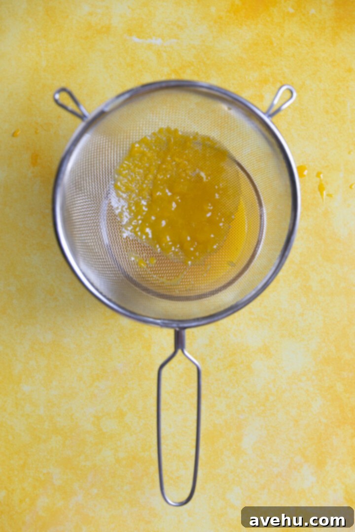 Pillowy Lemon Curd Muffins 7 A strainer over lemon curd.