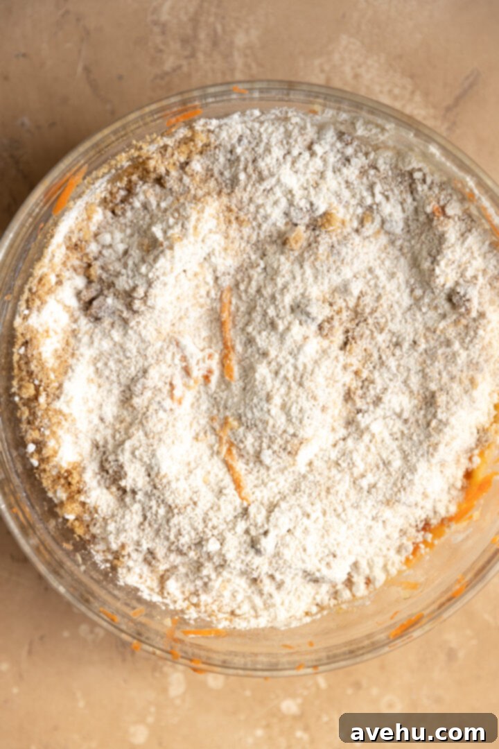 Kid-Approved Carrot Pineapple Muffins 5 Dry muffin ingredients being gently folded into the wet ingredients to prevent overmixing and ensure a tender crumb.