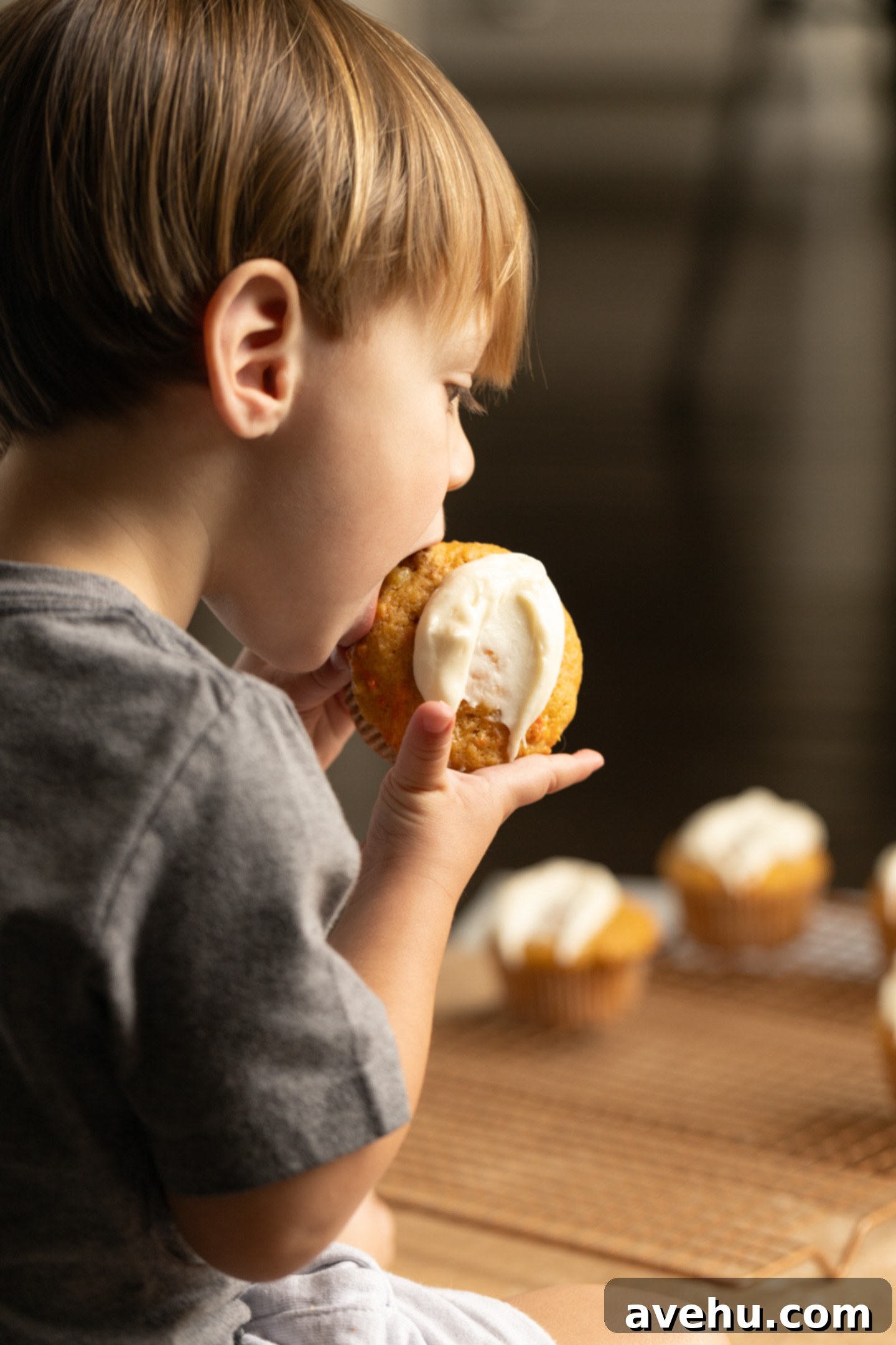 Kid-Approved Carrot Pineapple Muffins 10 A small child happily taking a bite out of a delicious carrot pineapple muffin, showing its kid-friendly appeal.