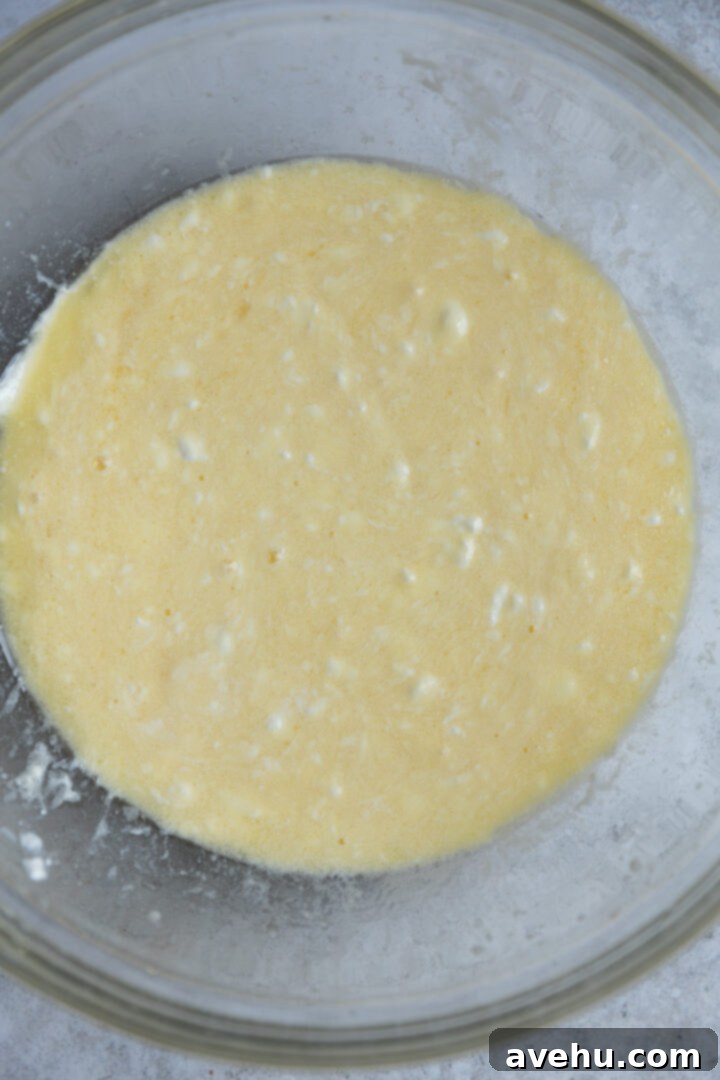 Lemon Poppy Seed Muffins Beyond Bakery Quality 5 A bowl filled with the wet ingredients for lemon poppy seed muffins, a creamy yellow mixture awaiting the dry components.