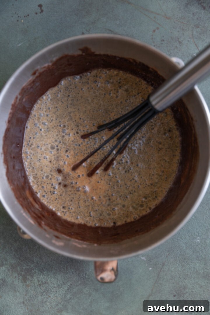 Guinness Kissed Chocolate Cake with Baileys Cloud 4 Smooth, rich chocolate cake batter in a large mixing bowl, ready for baking.