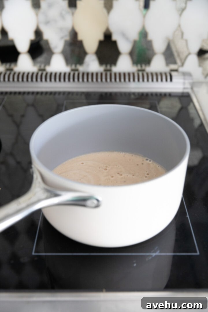 Guinness Kissed Chocolate Cake with Baileys Cloud 6 Guinness stout bubbling in a pan on the stove, beginning the reduction process.