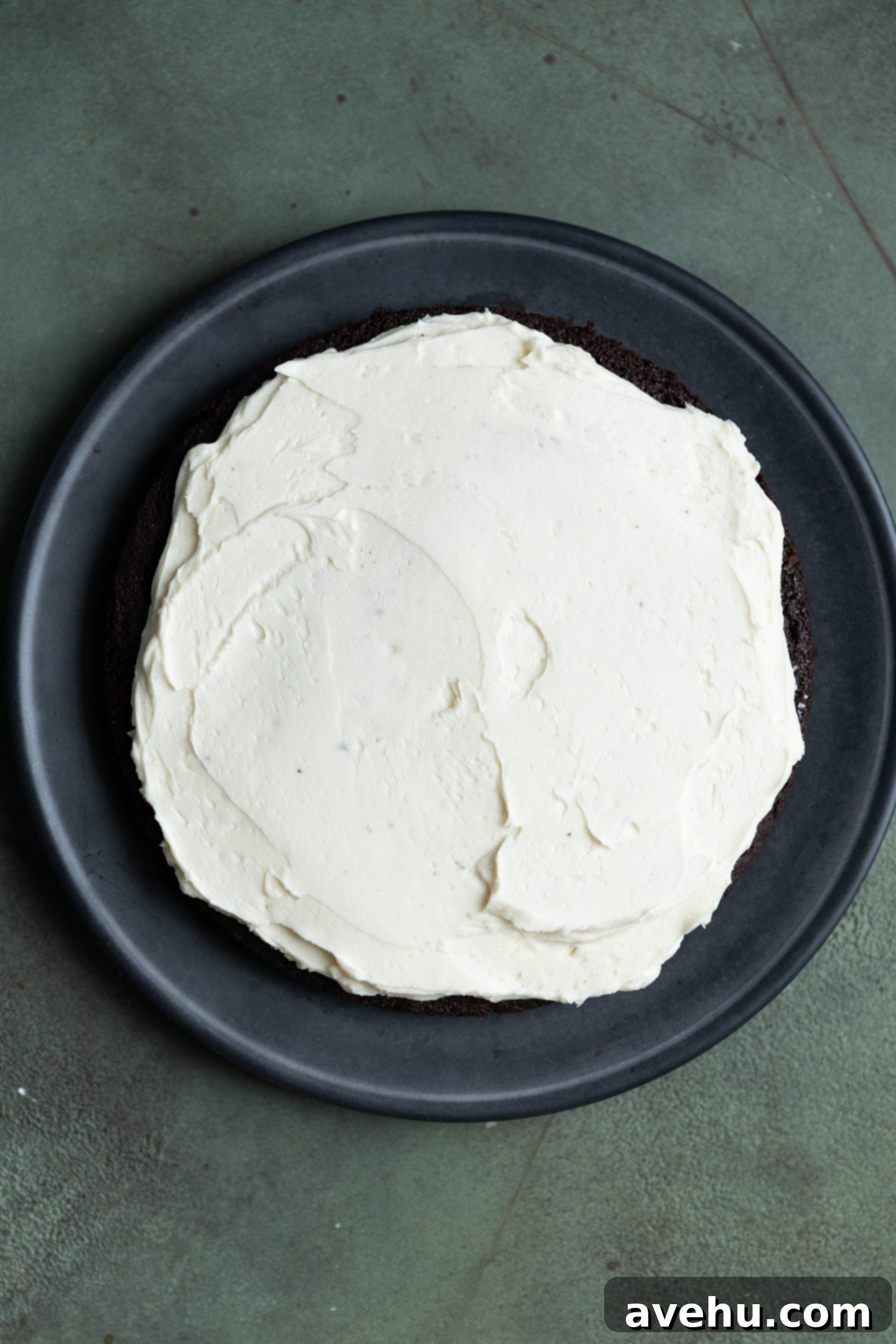 Guinness Kissed Chocolate Cake with Baileys Cloud 9 A luscious layer of white Baileys frosting spread over a dark chocolate cake layer, ready for stacking.